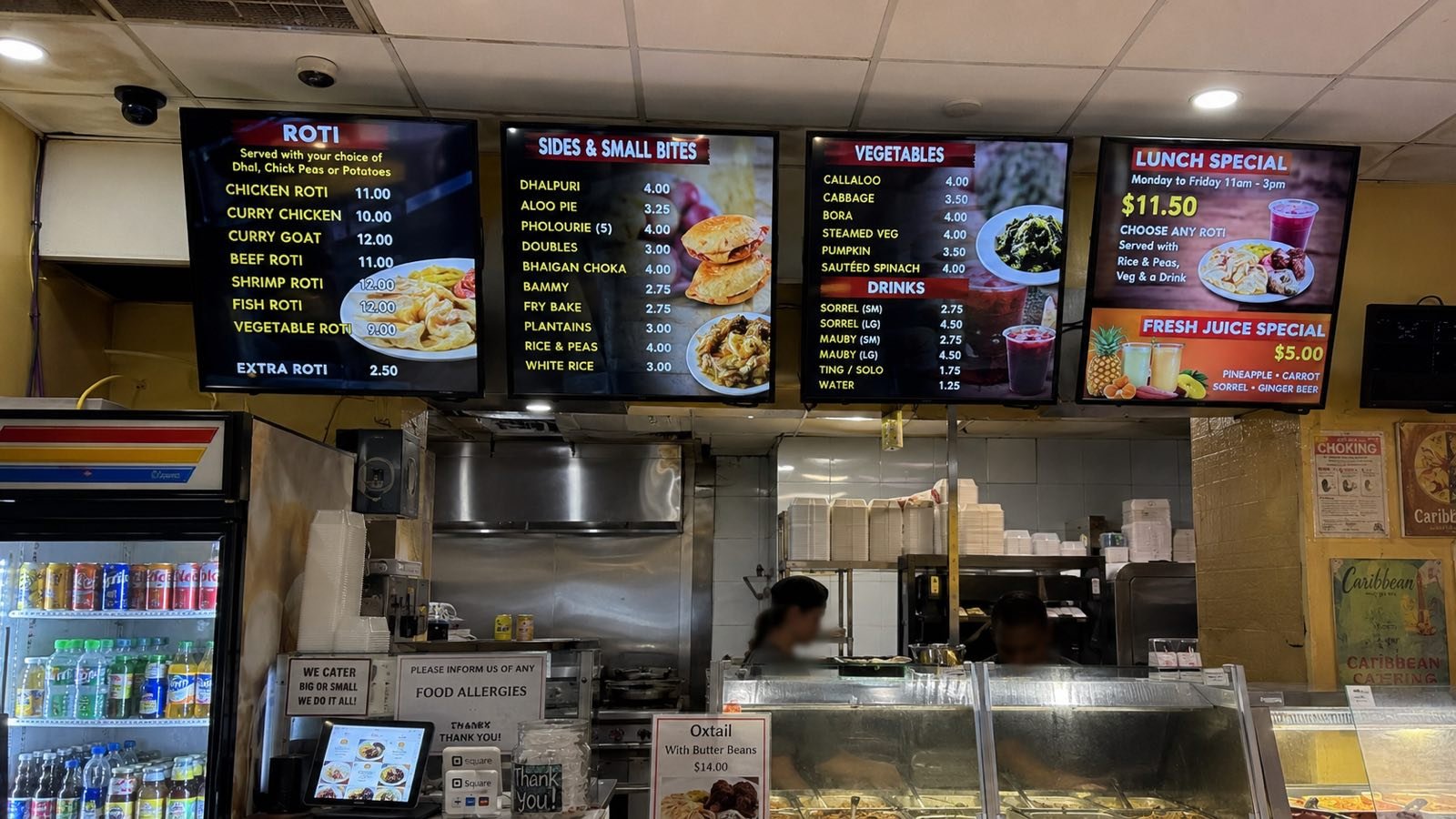 Illustrative example — SpotrOS digital menu boards in a Caribbean roti shop (restaurants run on our sister brand GrubSpotr)